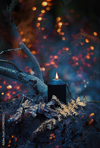Tableau sur toile magic black candle in mystery dark autumn forest, abstract natural background