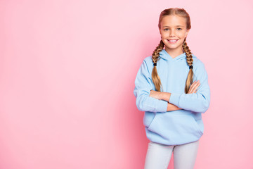 Photo of cheerful positive kind friendly cute girl standing confidently with arms crossed near empty space to be fulfilled with ads isolated over pastel color background