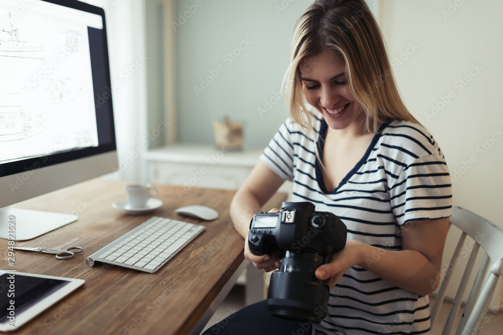 Young smiling beautiful designer holding digital camera Young smiling beautiful designer holding digital camera