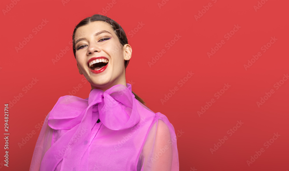 girl actress posing with positive emotion. in the Studio on a red background. girl opened her mouth in surprise girl actress posing with positive emotion. in the Studio on a red background. girl opened her mouth in surprise
