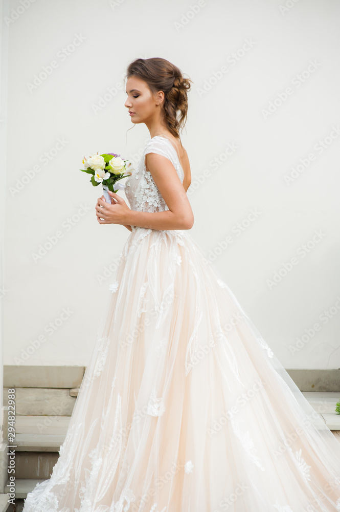 Beautiful bride in long wedding dress with bouquet Beautiful bride in long wedding dress with bouquet
