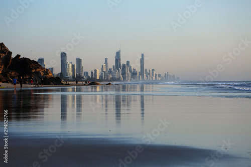 The city skyline of spectacular Surfers Paradise in Queensland  Australia  reflected in the wet sand on the beach at Burliegh Heads.