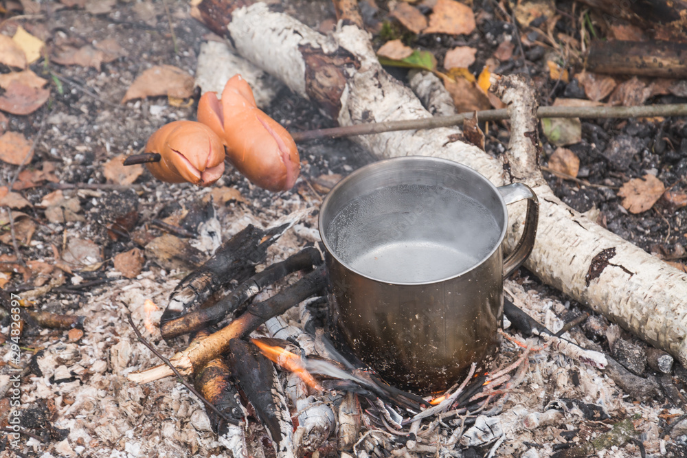 Traveler prepares food on fire Traveler prepares food on fire