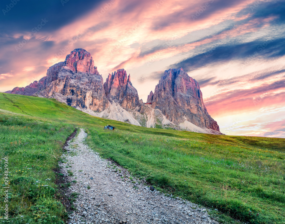 Naklejka premium Colorful morning view from Sella pass of Sassolungo and Sella mountain range. Fantastic summer sunrise scene of Gardena valley, National Park Dolomites (Dolomiti), South Tyrol, Alp, Italy, Europe.