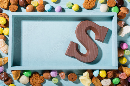 Traditional dutch chocolate latter S for childrens holiday Sinterklaas. Celebration of Saint Nicholas in Netherlands, blue box with colorful traditional sweets. Copy space, top view. photo