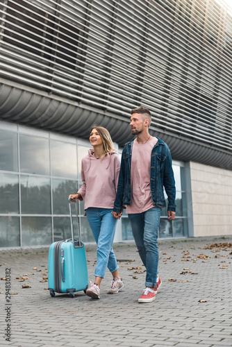 Couple holding hands when walking through airport terminal