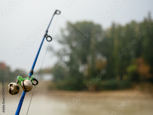 Fishing rod with bells to alert about the bite. Fishing rod in the fog on the river © LesdaMore