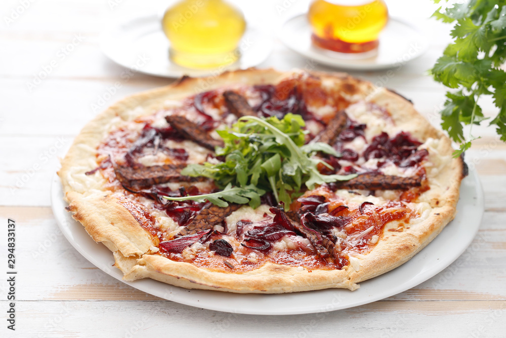 Vegan pizza with tomato sauce, smoked tempeh and red onions. Vegan pizza with tomato sauce, smoked tempeh and red onions.