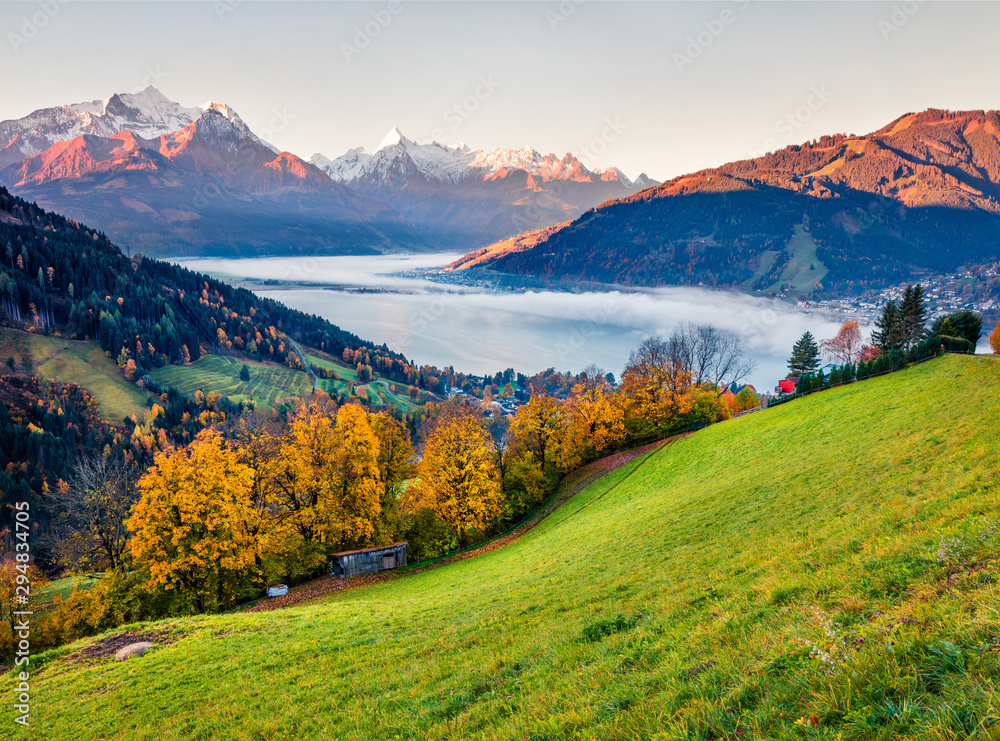 Wonderful view of Zell lake. Colorful autumn sunrise in Austrian town - Zell am See, south of the city of Salzburg. Beauty of nature concept background.