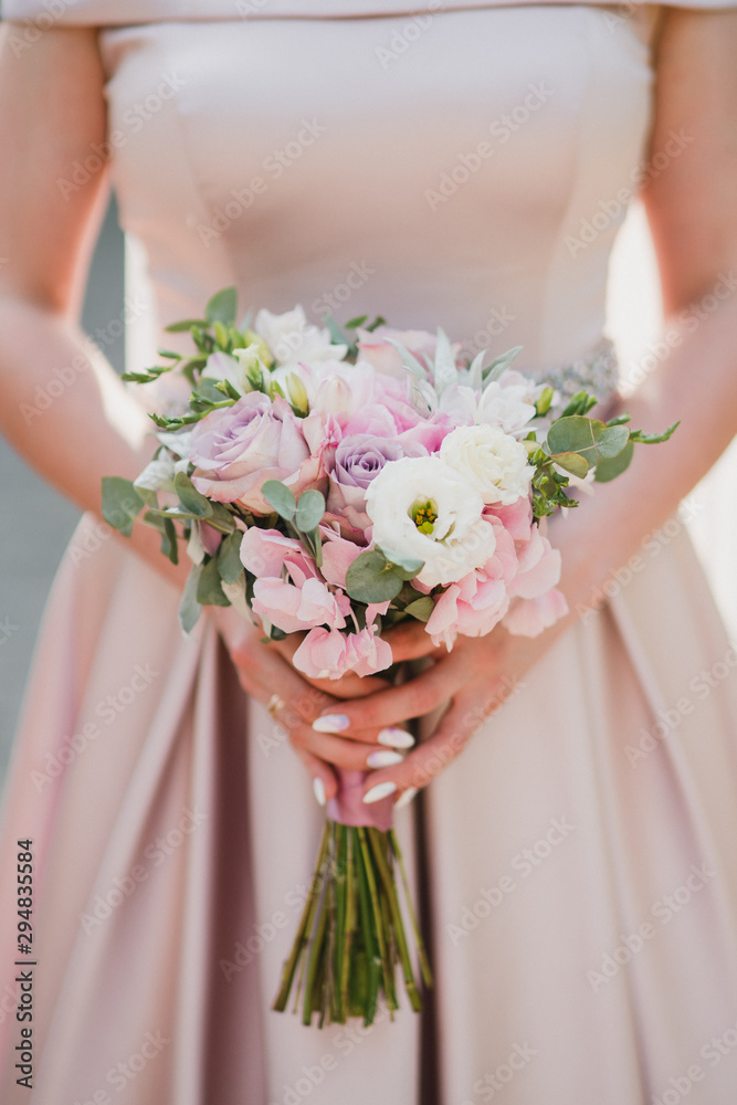 Modern bridal style. Closeup of caucasian bride holding a beautiful bouquet of colorful fresh flowers in her hands. Modern bridal style. Closeup of caucasian bride holding a beautiful bouquet of colorful fresh flowers in her hands.