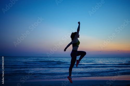 healthy sports woman on seashore in evening training