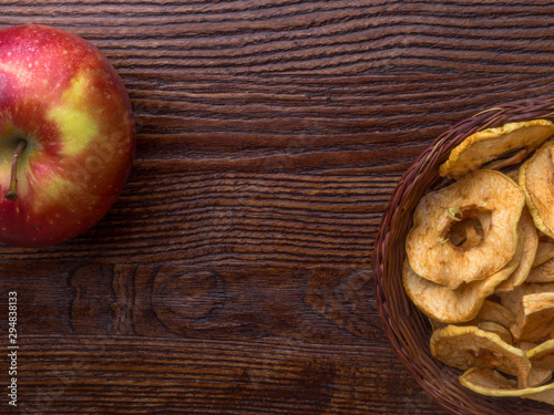 Healthy snack. Homemade dehydrated apple chips on rustic wooden background
