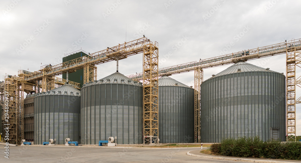 Modern elevator for storing grain against the sky. Grain drying complex, storage and transportation of grain. Large granary in the field. Agricultural industry