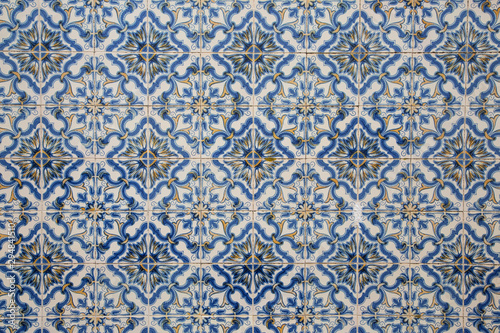 Ornate pattern, for design, backdrop. Abstract background from decorative painted tiles, close up. Fragment of old building wall, with traditional Portuguese, glazed ceramic tiles. White and blue colo