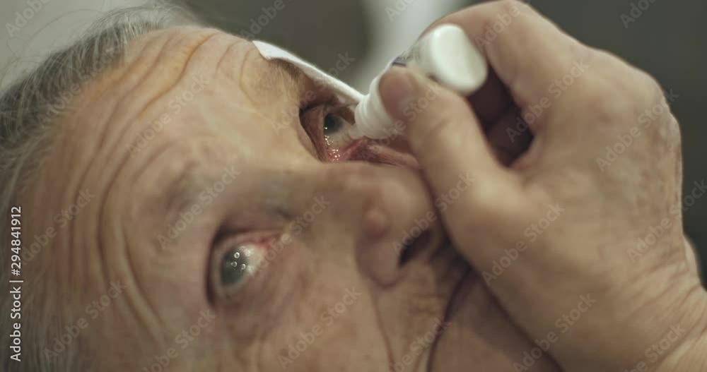 Senior woman putting eye drop in injured eye