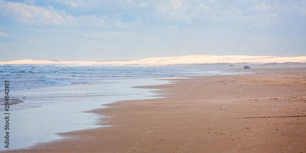 Coastal seascape with breaking waves, sand and sand dunes Coastal seascape with breaking waves, sand and sand dunes