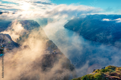 Foggy morning view of popular Norwegian attraction Preikestolen. Great summer scene of the Lysefjorden fjord, located in the Ryfylke area in southwestern Norway. Beauty of nature concept background.