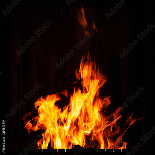 Fire flame on a black background. Burning fire at night. Bonfire in the barbecue, fireplace and hearth.