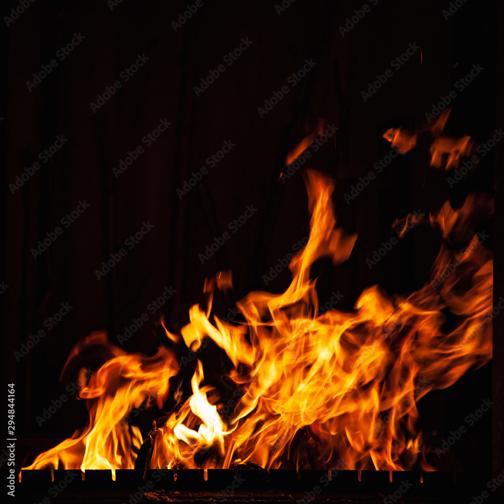 Fire flame on a dark background. Burning fire at night. A fire in the grill, fireplace and hearth.