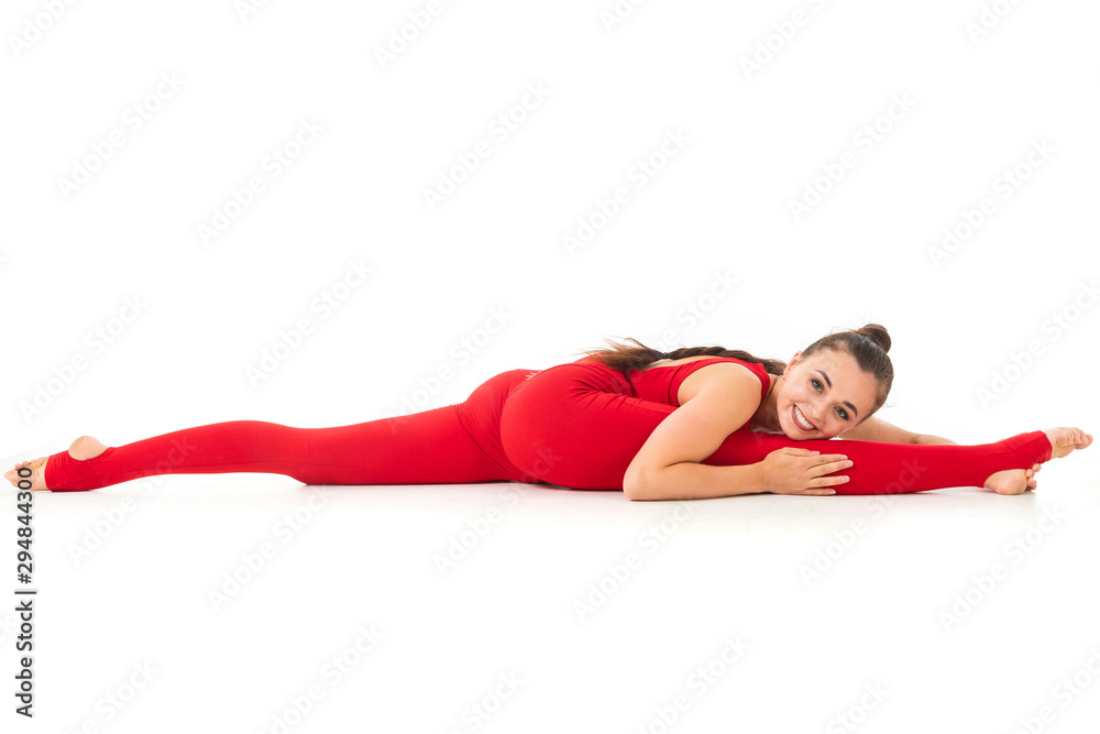 A beautiful young woman gymnast with dark long hair stuffed in a horse tail in a red sports elastic suit sits on a twine A beautiful young woman gymnast with dark long hair stuffed in a horse tail in a red sports elastic suit sits on a twine