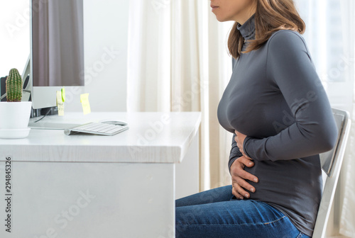 Period concept. Pain in the ureter or stomach of a woman at her desk. Diarrhea.