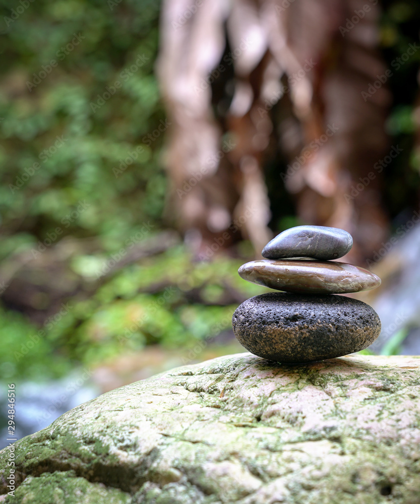 Stacked pebbles in the garden. Zen, spa or wellness concept. Stacked pebbles in the garden. Zen, spa or wellness concept.