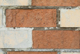 White and red brick wall with concrete in the gaps