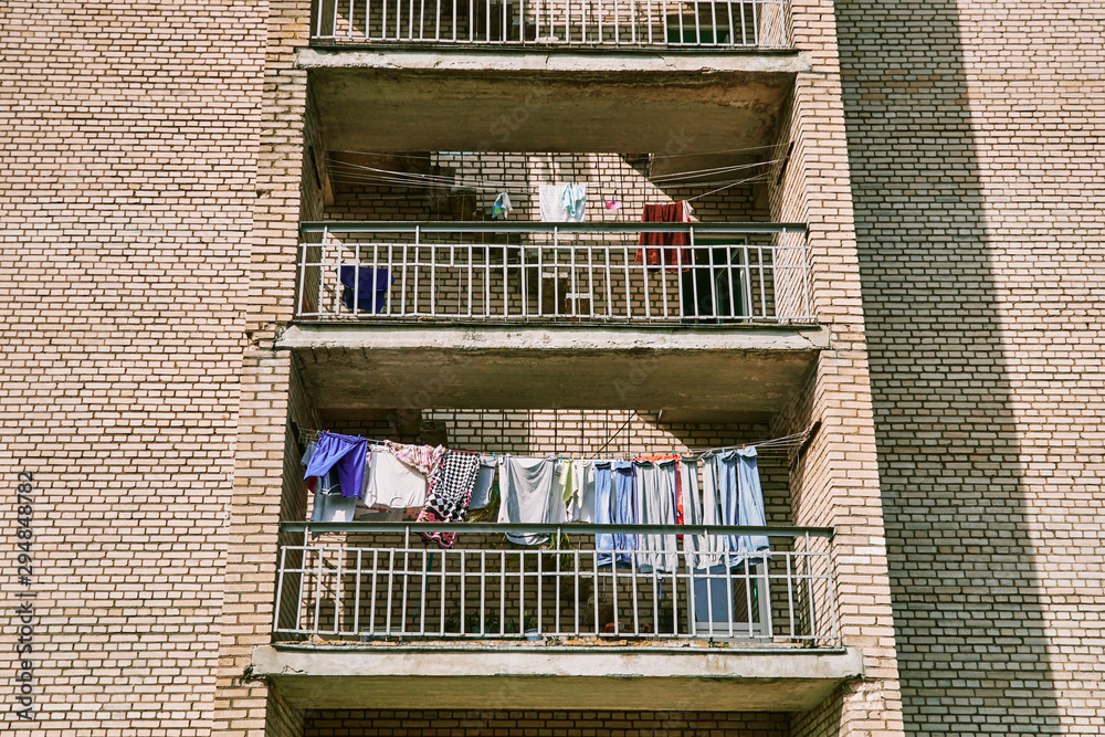 residential building with balconies. clean clothes and linen are dried outside.
