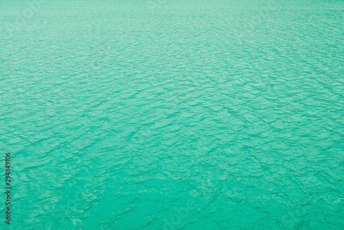 Clean transparent water surface of mountain lake texture for background. Neo mint color trend of the year 2020.