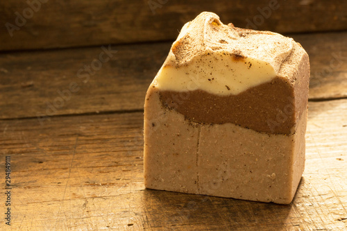 Natural handmade soap with cocoa and cinnamon on wooden background and copy space