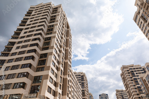 Ground view of multitier modern apartment buildings at blue sky background on sunny day photo