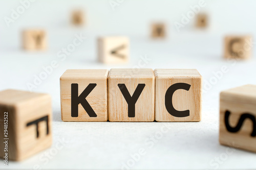 KYC - acronym from wooden blocks with letters, abbreviation KYC know your customer concept, random letters around, white  background