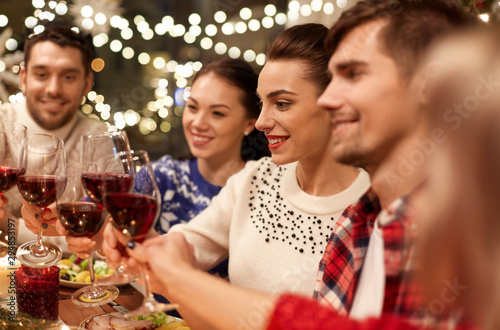 Photography holidays and celebration concept - happy friends having christmas dinner at home