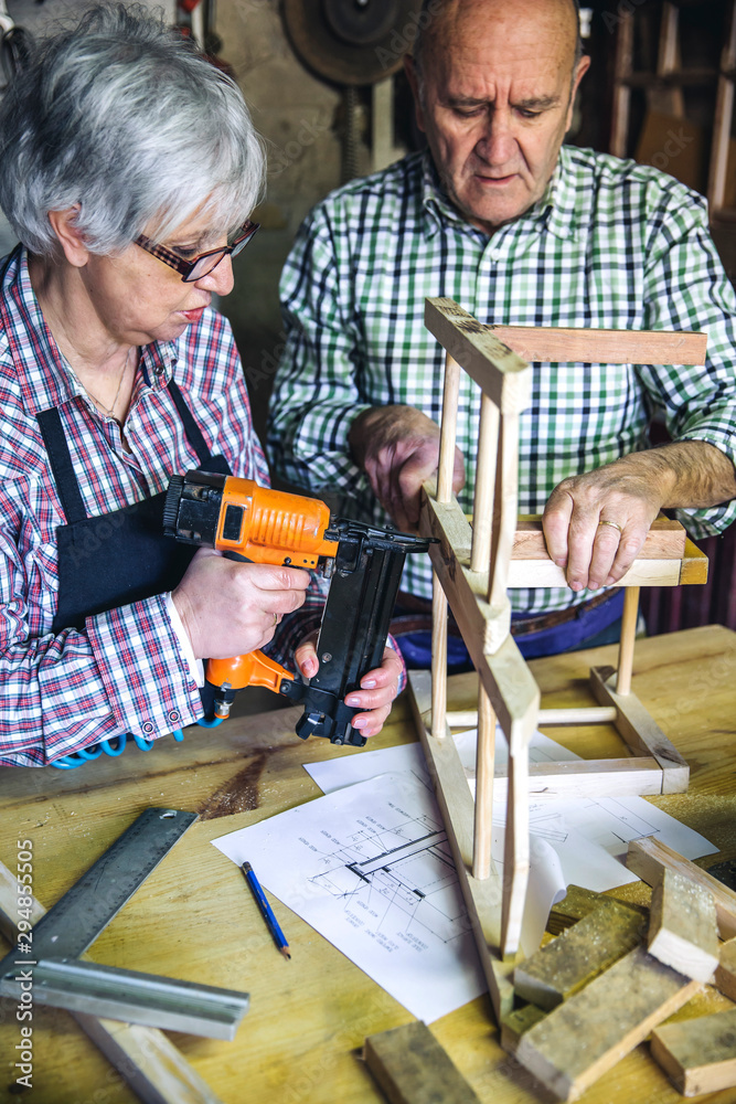 Senior couple working in a carpentry workshop Senior couple working in a carpentry workshop
