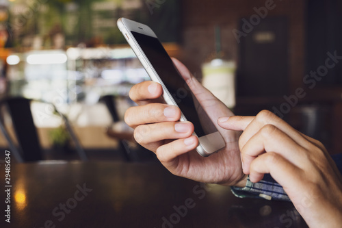 Women holding and touch mobile smart phone with blank screen in cafe