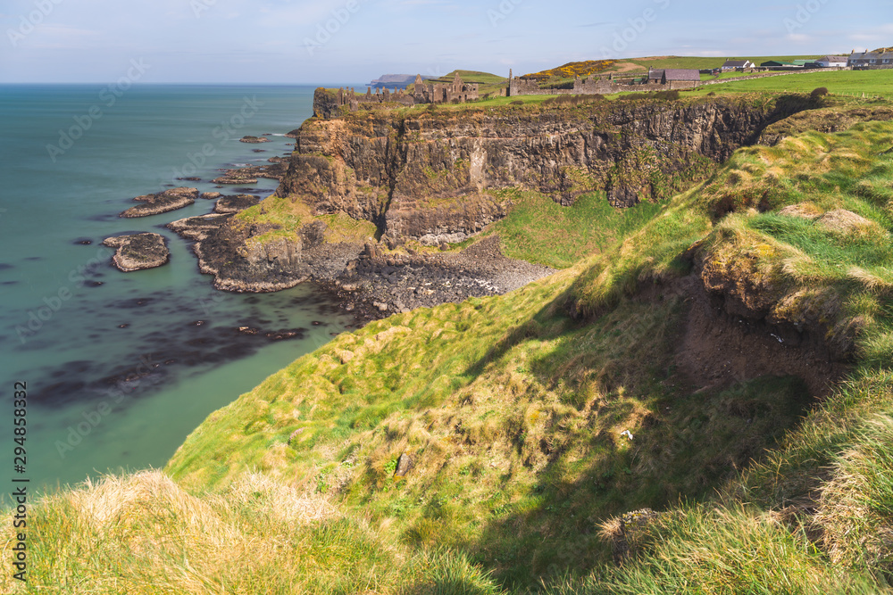 Early morning sunlight over Dunluce Castle at the Causeway Coast of Northern Ireland