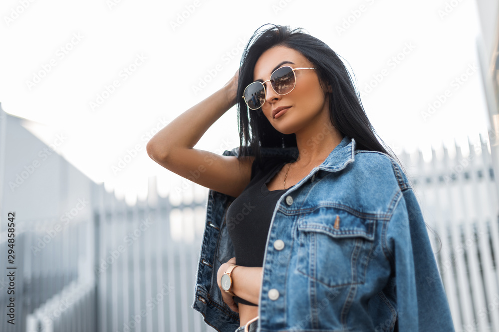 Pretty stylish young hipster woman in a trendy black t-shirt in sunglasses  in a vintage