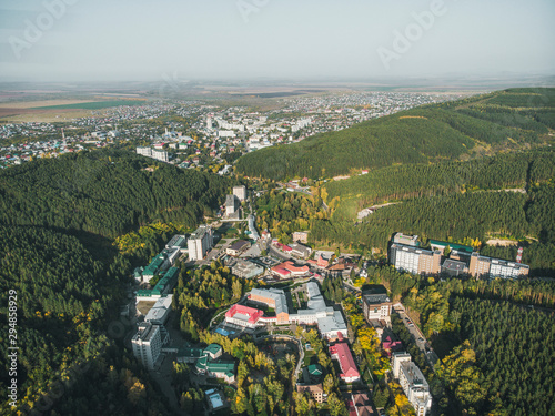 Aerial view of a small town in the Altai territory. Top view of the resort town Belokurikha. Bird's-eye view of the houses among the forests on the slopes of the mountains. photo