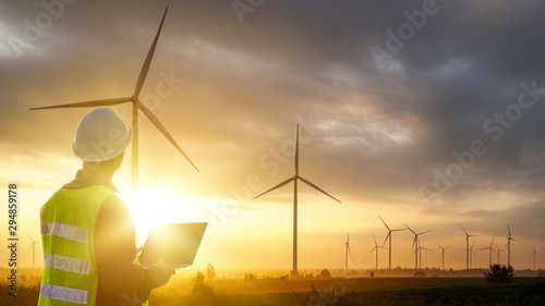 Silhouette of Technician Engineer  at wind turbine electricity industrial in sunset