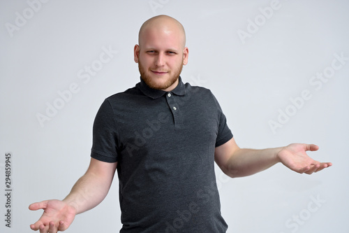 Fotografija Portrait of a handsome bald man in a gray t-shirt on a white background in the studio