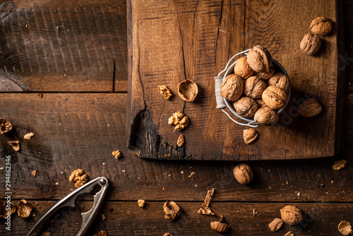 Walnuts in metal pail on wooden table