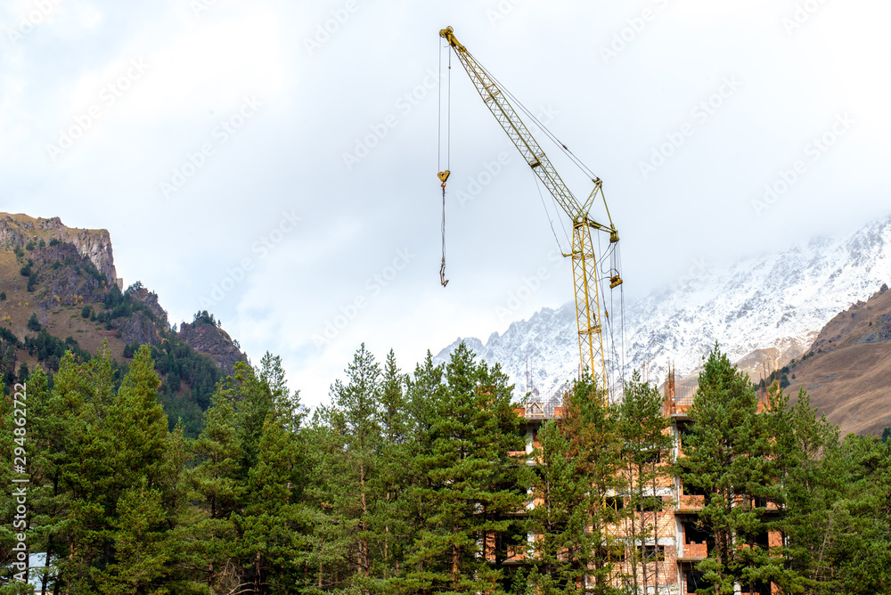 construction of a multi-storey building in the mountains, a tower crane