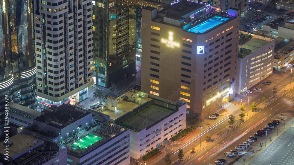 Car parking lot with rooftop swimming pool viewed from above night timelapse, Aerial top view. Dubai, UAE Car parking lot with rooftop swimming pool viewed from above night timelapse, Aerial top view. Dubai, UAE