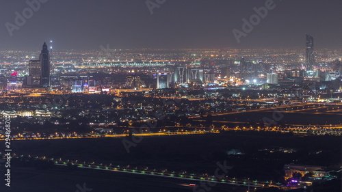 Aerial view to Creek and zabeel district night timelapse with traffic and under construction building with cranes from downtown