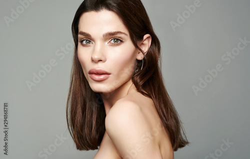 Glamour portrait of beautiful brunette woman model with fresh daily makeup and romantic hairstyle. Fashion shiny highlighter on skin, sexy gloss lips make-up and dark eyebrows.