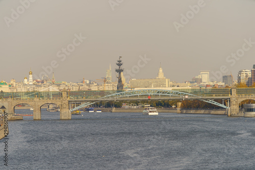 Moskva River and Peter the Great Statue made of Zurab Tsereteli in summer day. Famous historical monument in natural light. Ancient / old buildings on the embankment.