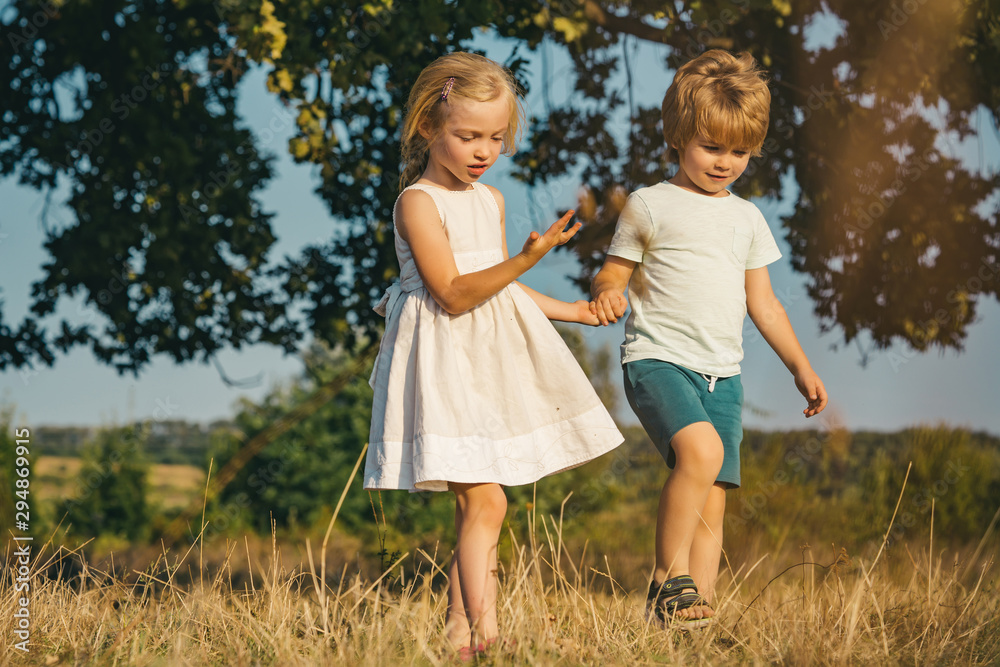 Fototapeta premium Eco living. Son and daughter planting on ground. sweet childhood. Little farmer in village. Active children concept. Summer leisure. Childhood on countryside.