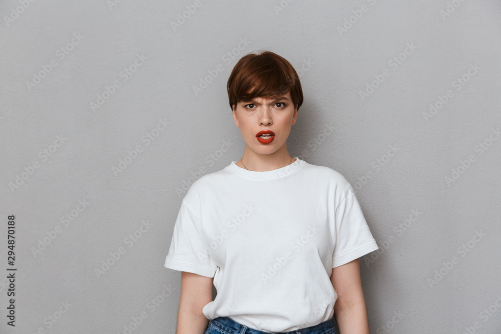 Image of puzzled brunette woman frowning and looking at camera Image of puzzled brunette woman frowning and looking at camera