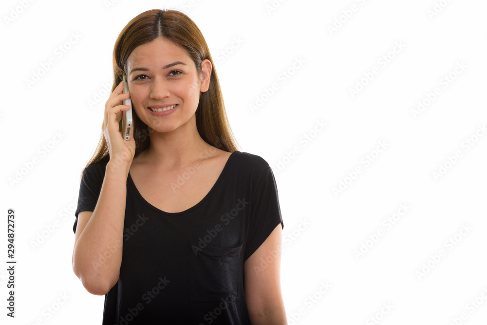 Studio shot of young happy woman smiling while talking on mobile Studio shot of young happy woman smiling while talking on mobile