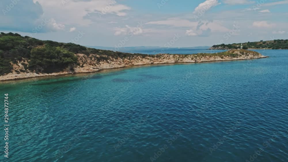 Drone pan shot left to right of coastline, sea and mountains under sunny cloudy sky with boat drifting on background. Pan shot of island under sunny cloudy sky and mountains Drone pan shot left to right of coastline, sea and mountains under sunny cloudy sky with boat drifting on background. Pan shot of island under sunny cloudy sky and mountains
